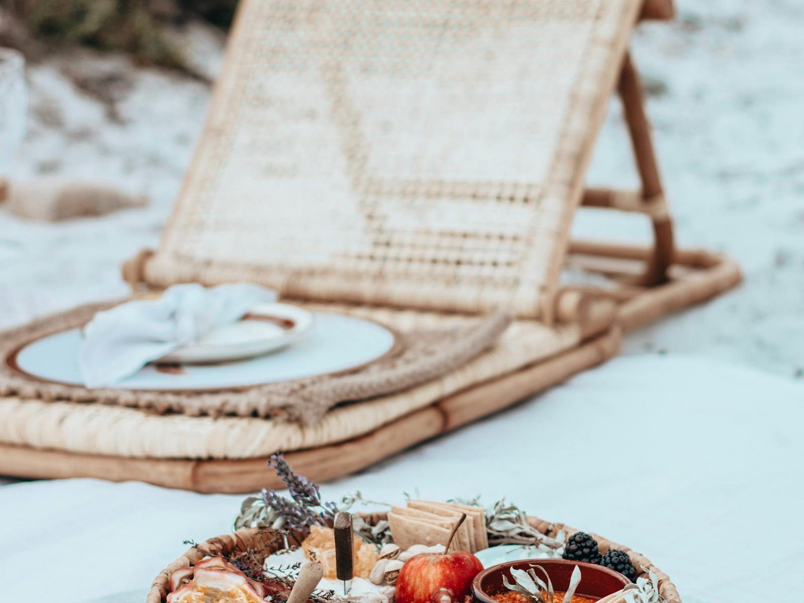 Beach picnic with wicker chair and gourmet platter