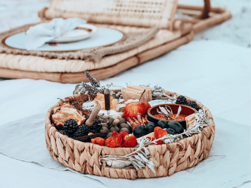 Beach picnic with wicker chair and gourmet platter