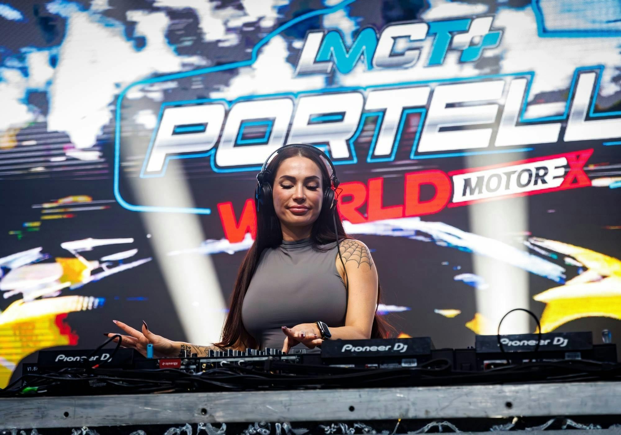 Female DJ performing behind a mixing desk on the Portelli World stage at MotorEx.
