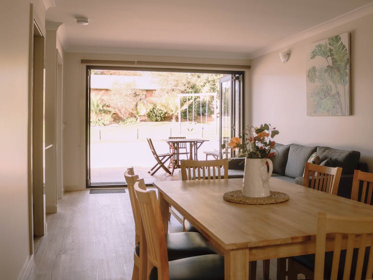 Dining room, lounge room with bifold doors that open onto deck with outdoor setting