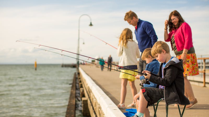 Family (mum, dad & kids) fishing of the pier.