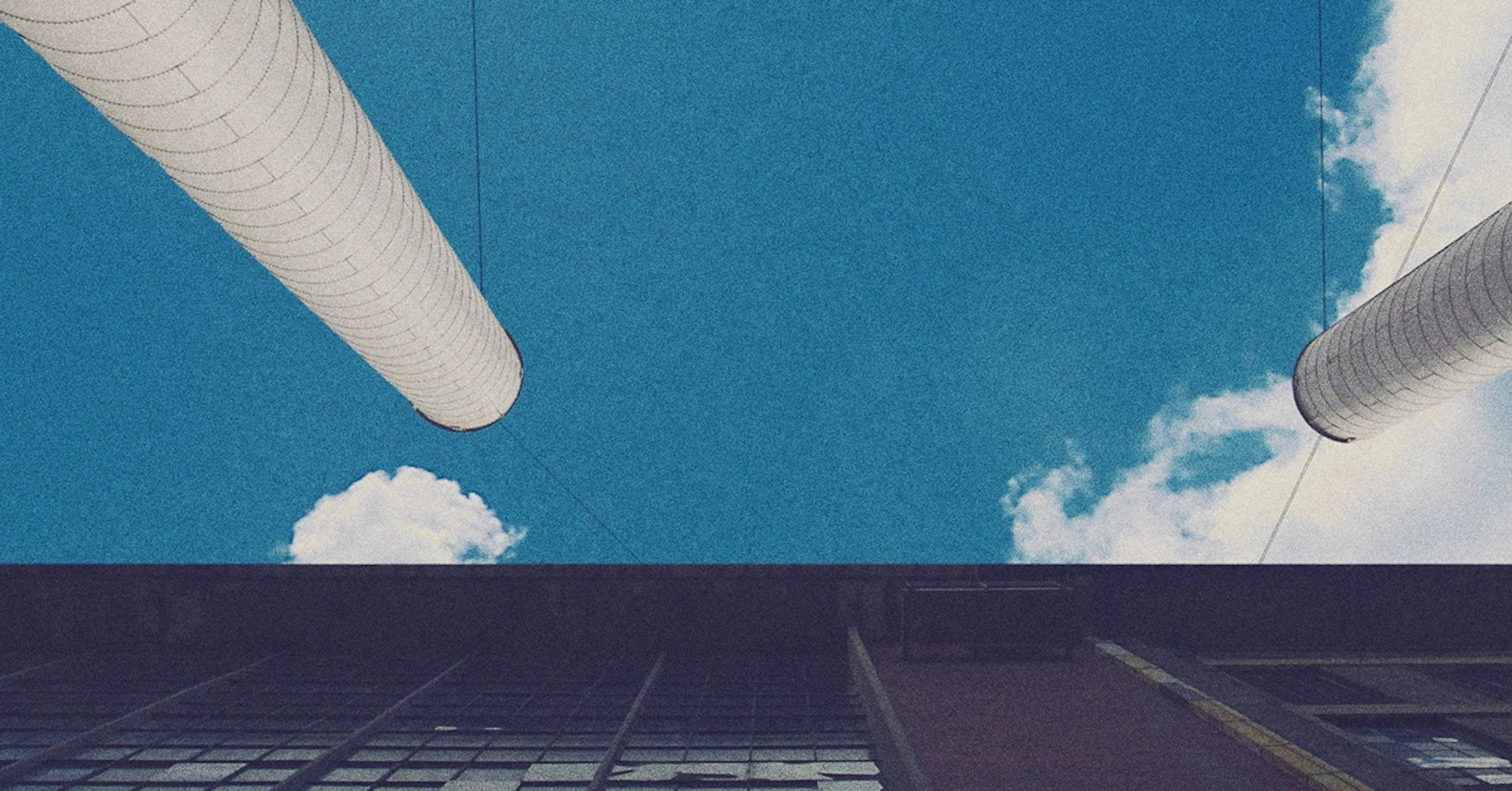 a building and pipes reach towards the blue sky