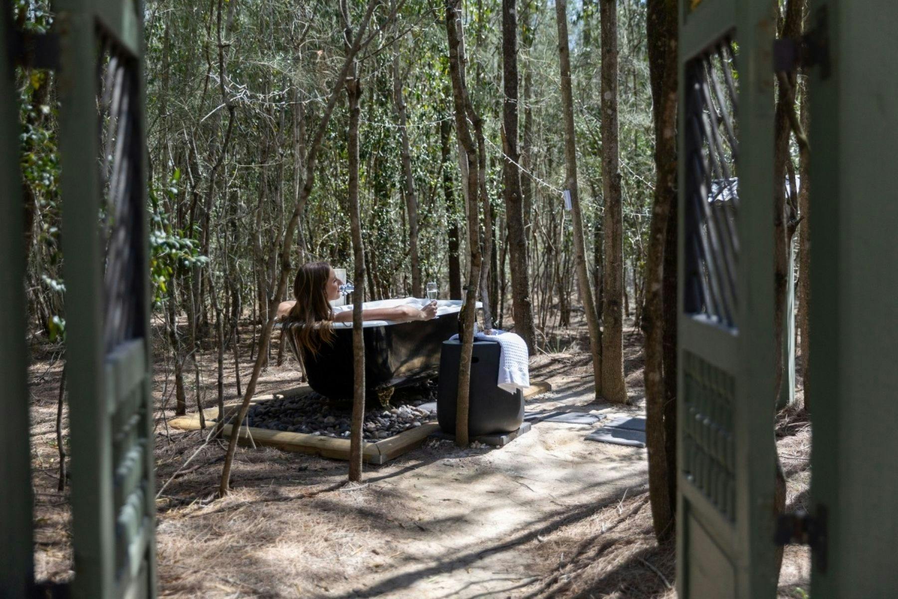 The outdoor bath located at Tree Tops under a canopy of fairy lights