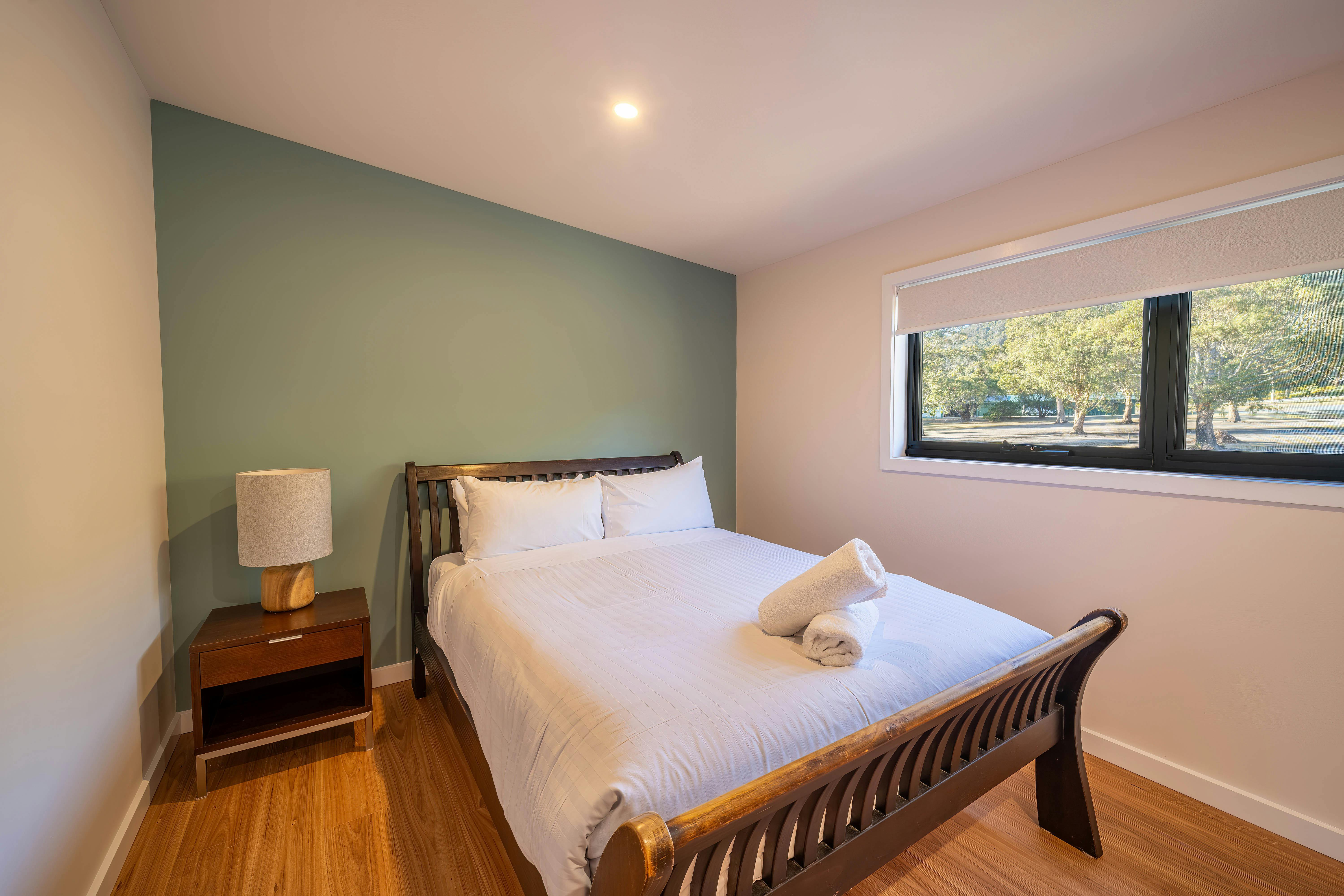 Bedroom area with bed, bedside table and lamp