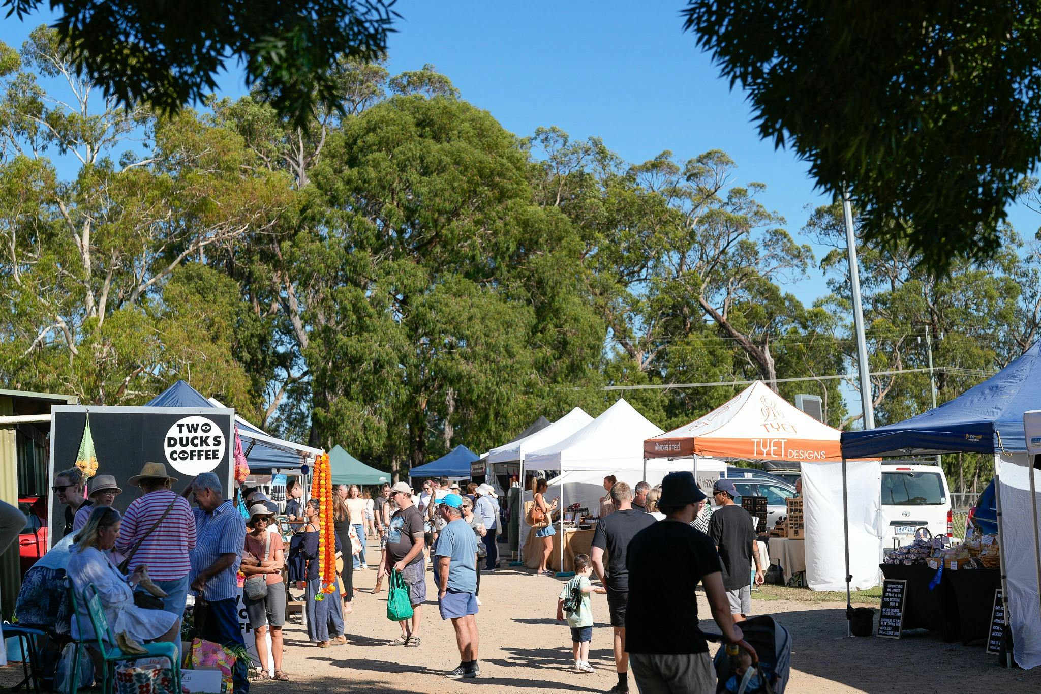 A lively outdoor market scene with people exploring stalls