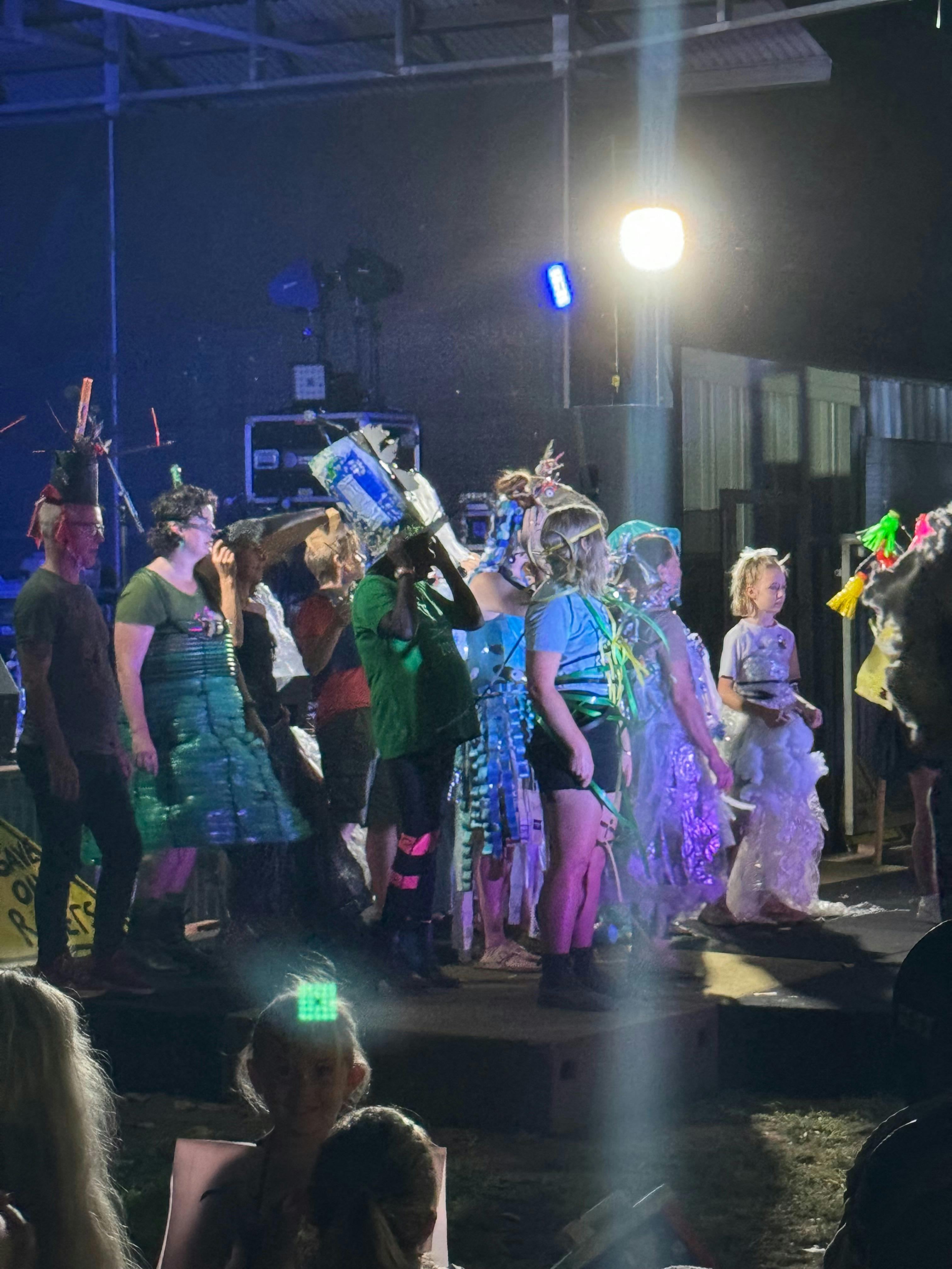 Large group of people from children to adults wearing outfits made out of rubbish!