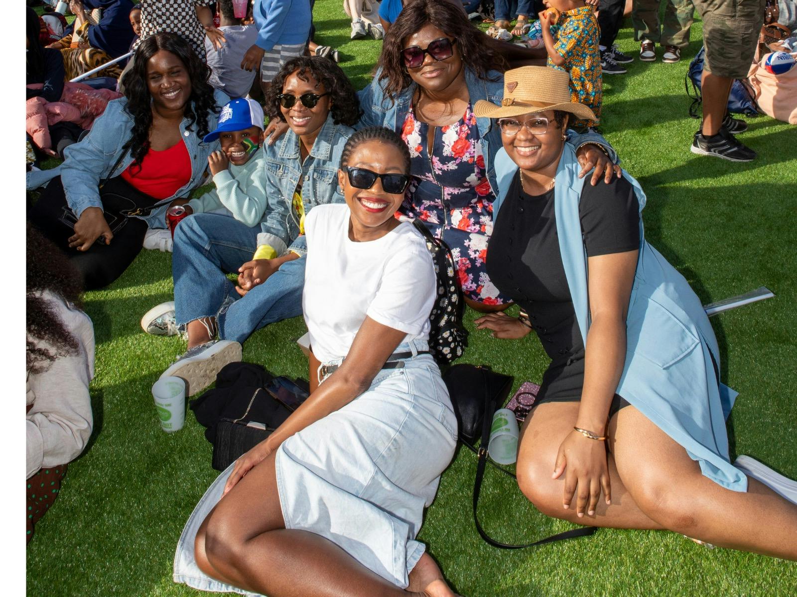 5 ladies relaxing on the grass enjoying the African music at Fed Square