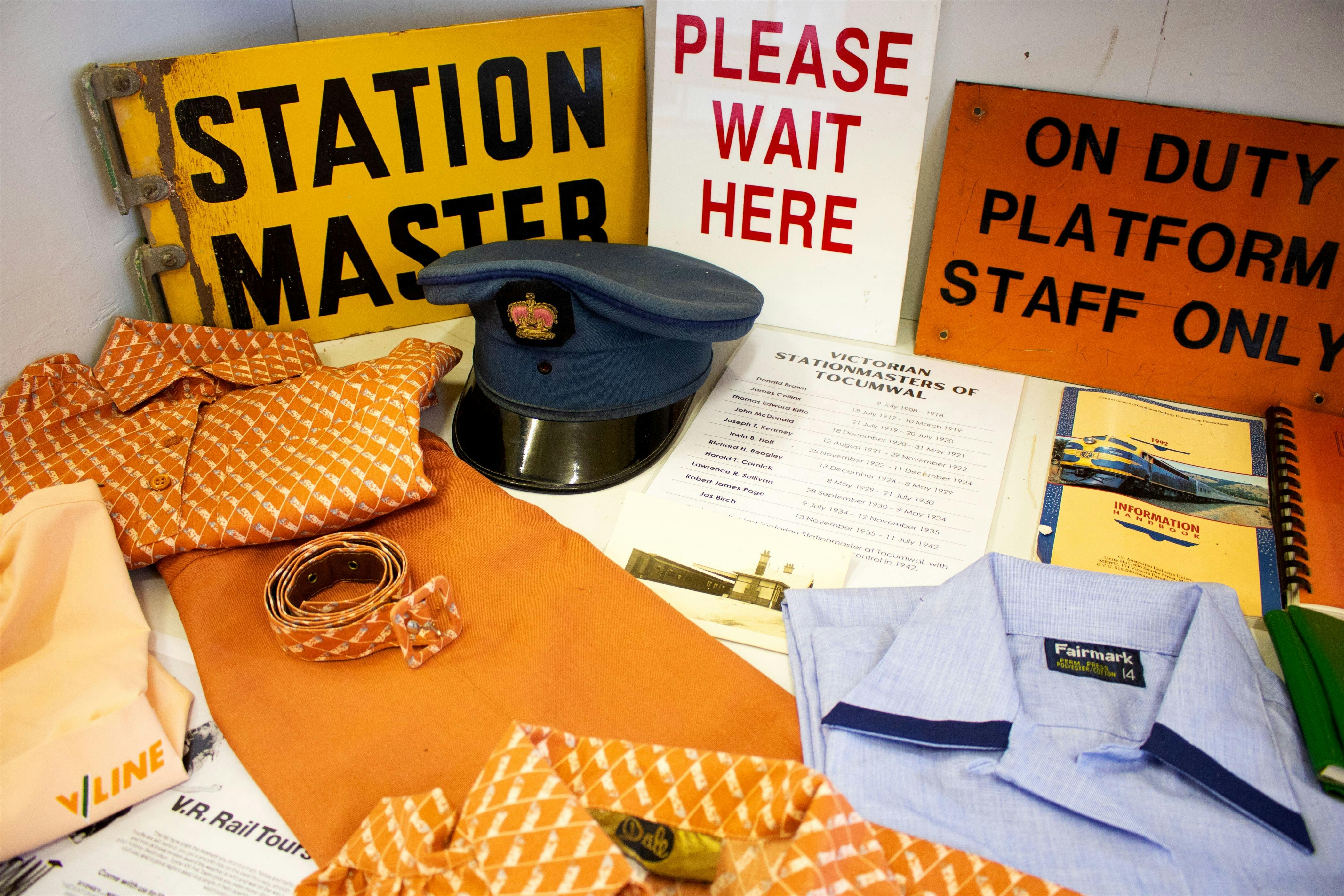 Mueseum cabinet display, featuring a railway uniform and hat, and railway platform signs