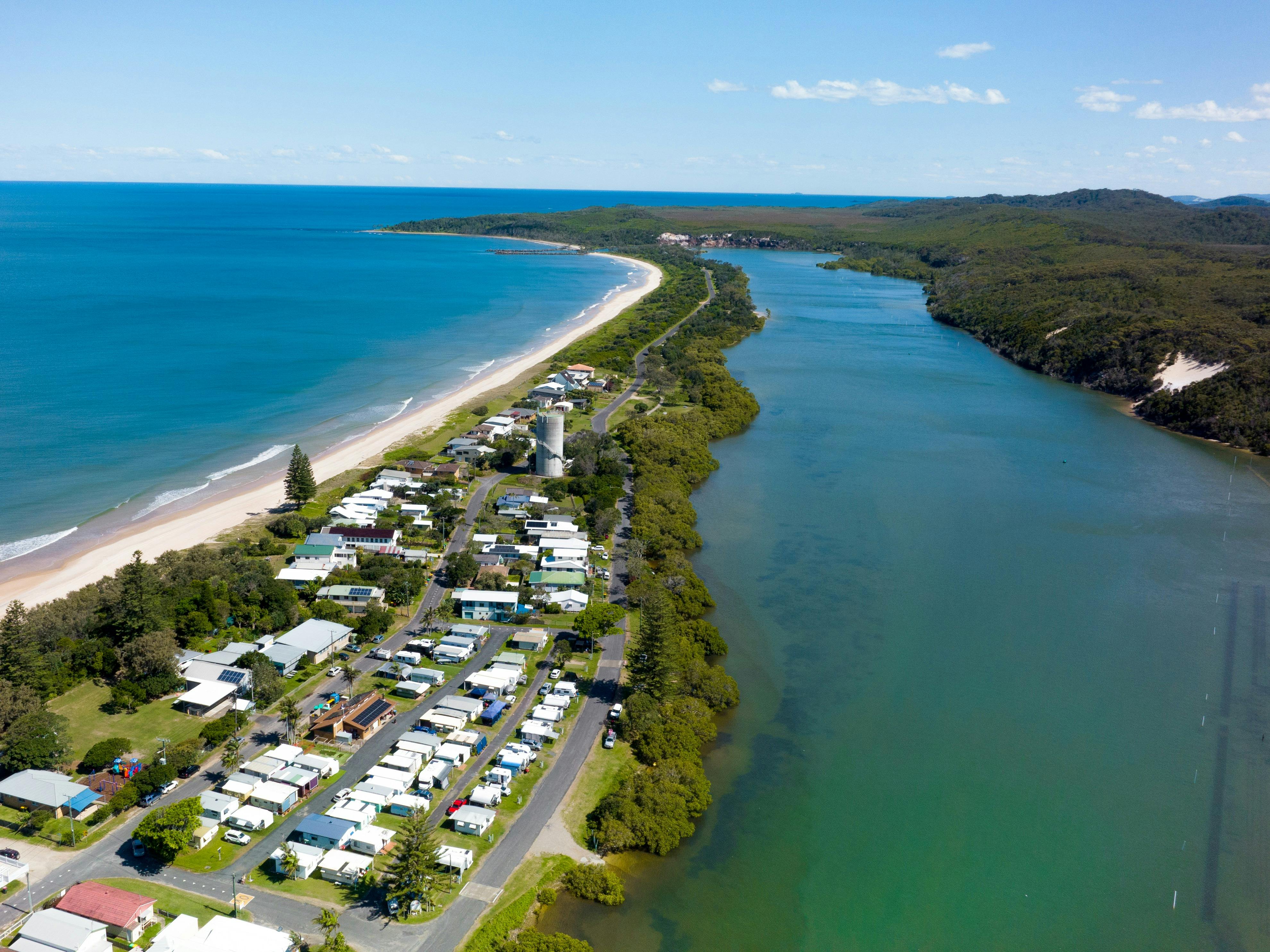 从空中拍摄的位于海洋和河流之间的露营地照片
