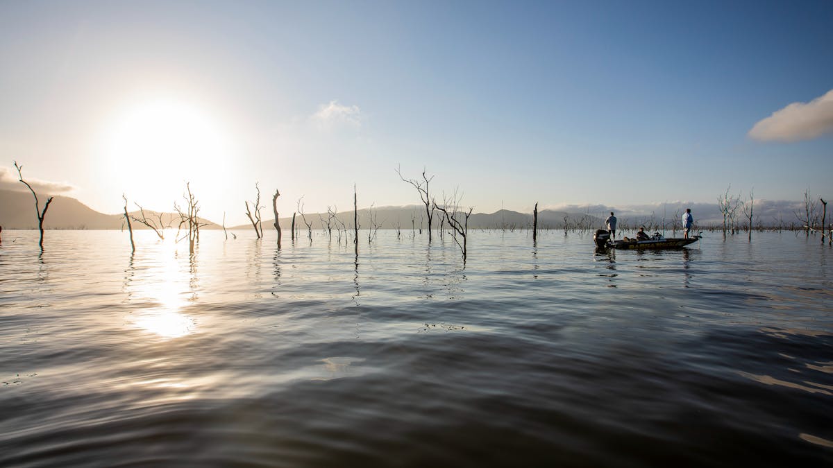 Fishing boat in the calm waters of Lake Proserpine with sun setting in the background