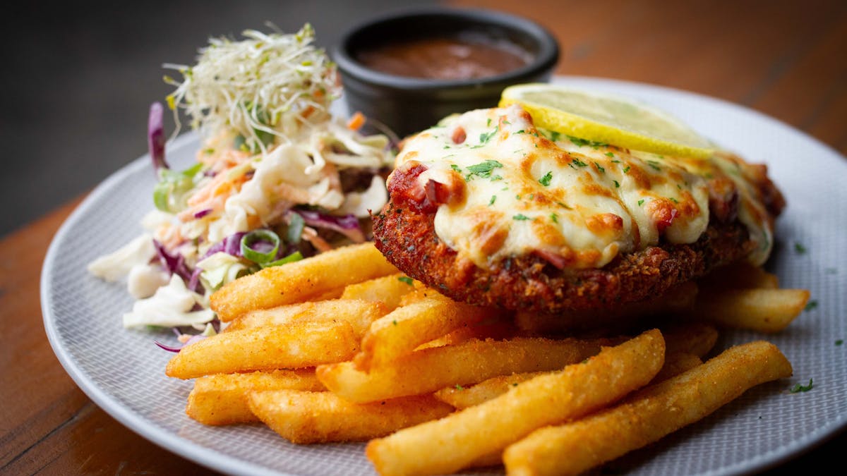 A Chicken Parmigiana with chips and slaw