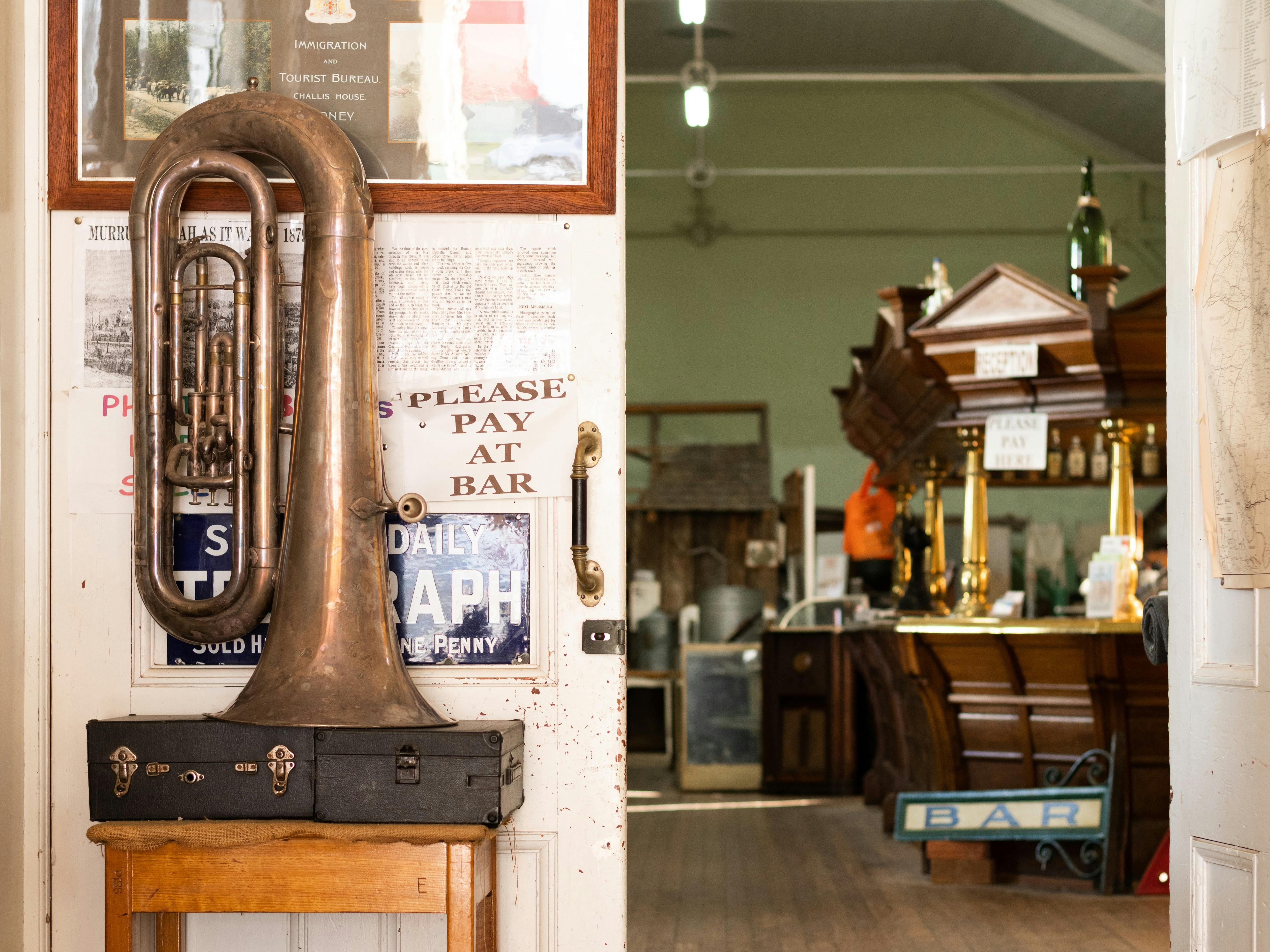 Secondary entrance into the museum, a tuba next to the door. Inside a large hall with old bar.