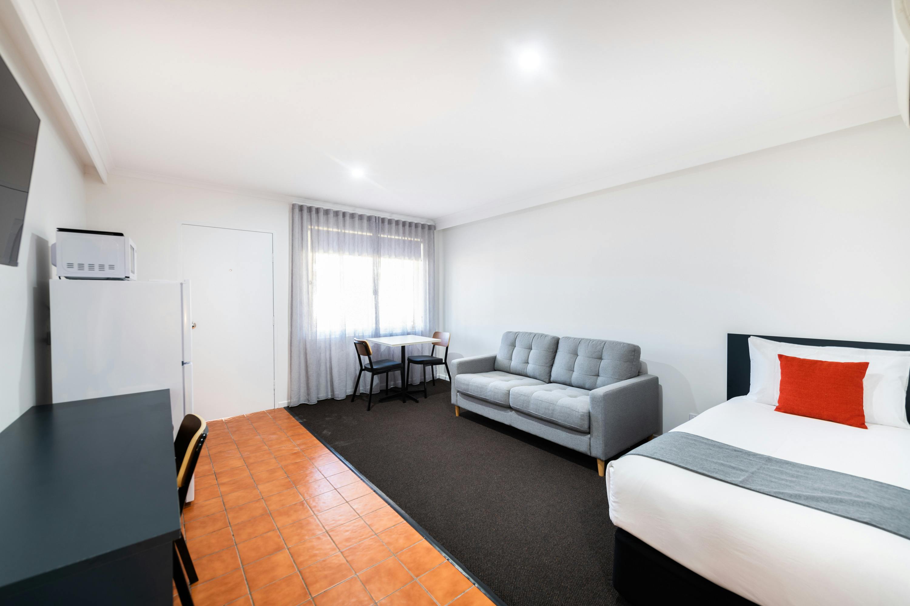 추가 싱글 침대와 소파 베드가 포함된 River Motel의 패밀리 스위트룸에 있는 넓은 거실 공간.