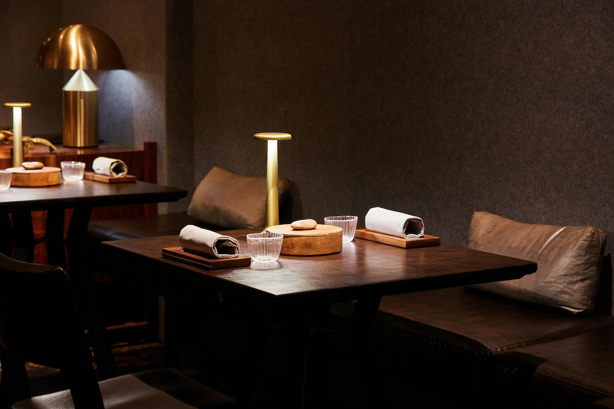 image of dimly lit dining room with an elegant place setting on a table for two