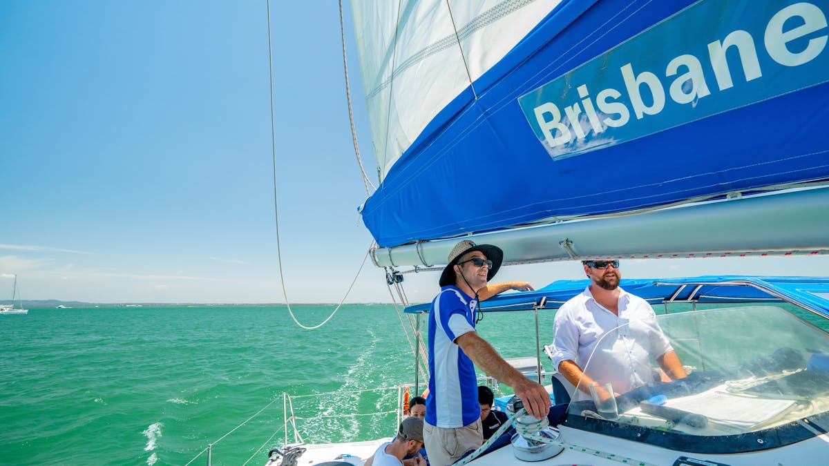 Passenger learning to sail in the pristine waters of Moreton Bay with Brisbane Yacht Charters
