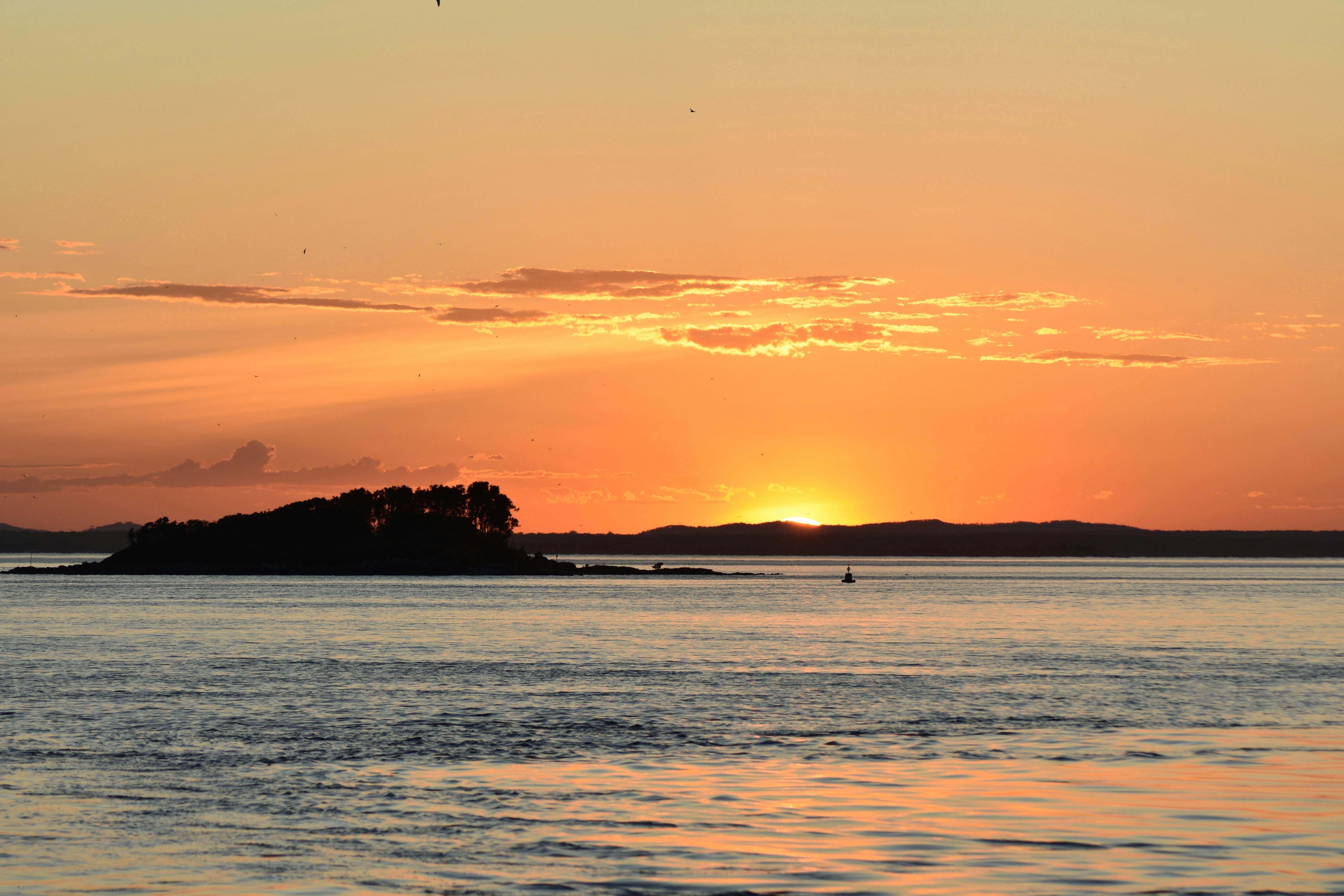 Blick auf den Sonnenuntergang hinter einer Insel
