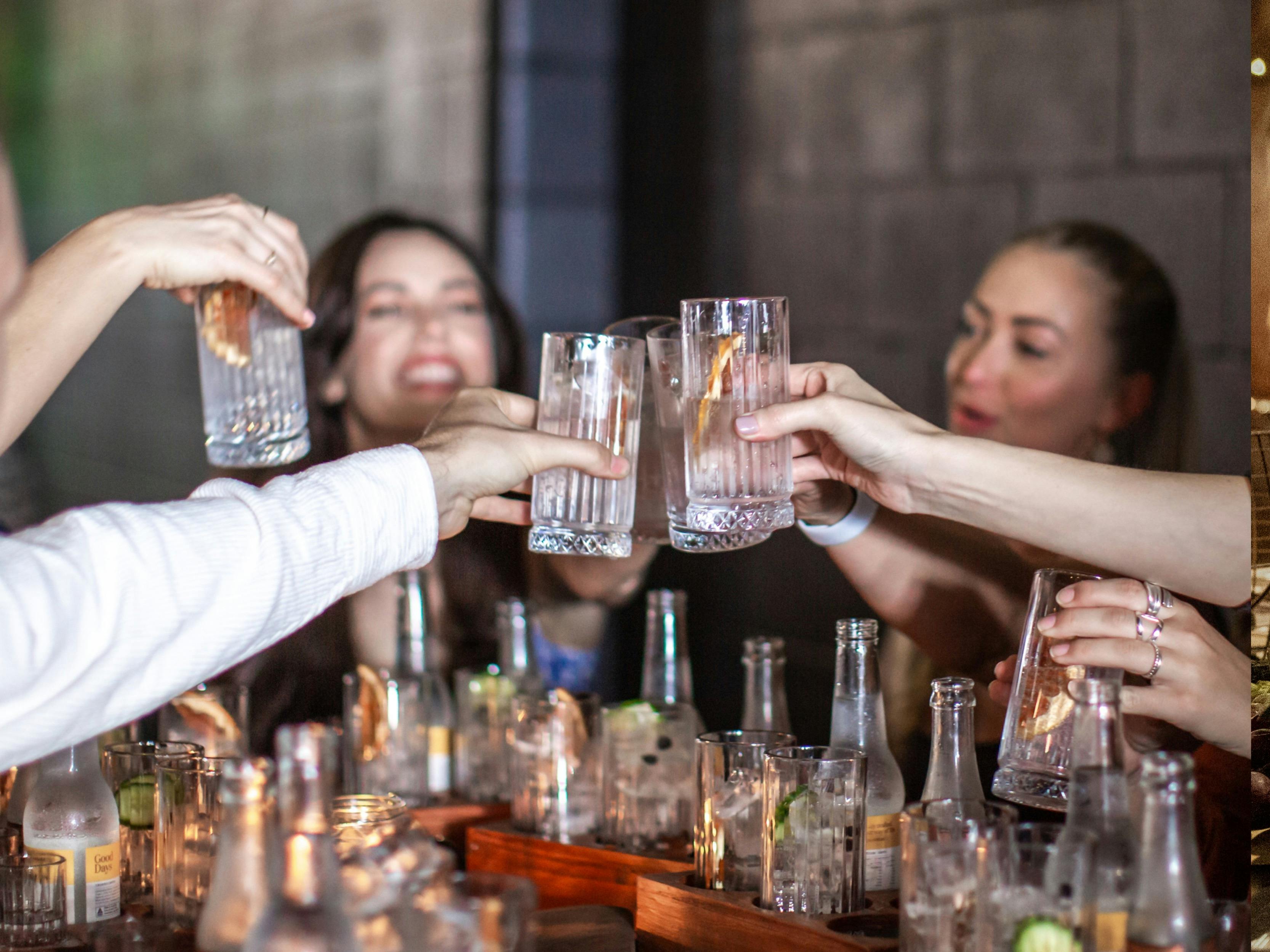 Guests clinking their glasses over a couple of gin tasting boards.