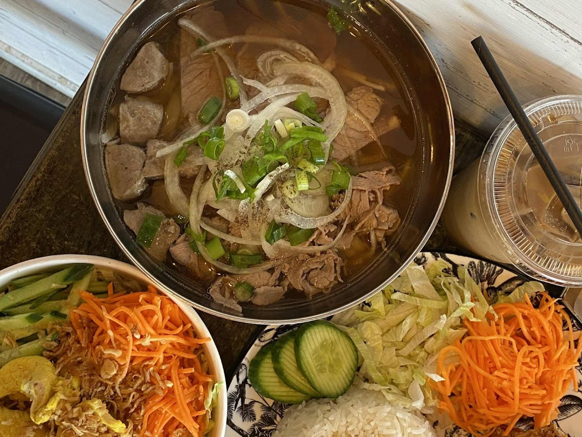 A bowl of Pho, side salad and a cup of coffee A bowl of Pho, side salad and a cup of coffee