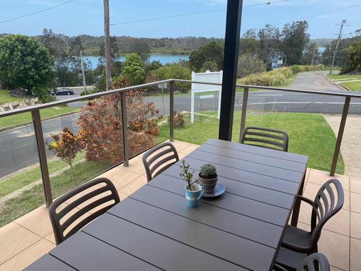 Shows 6 seater outdoor dining setting with succulents on table and view to Nambucca River