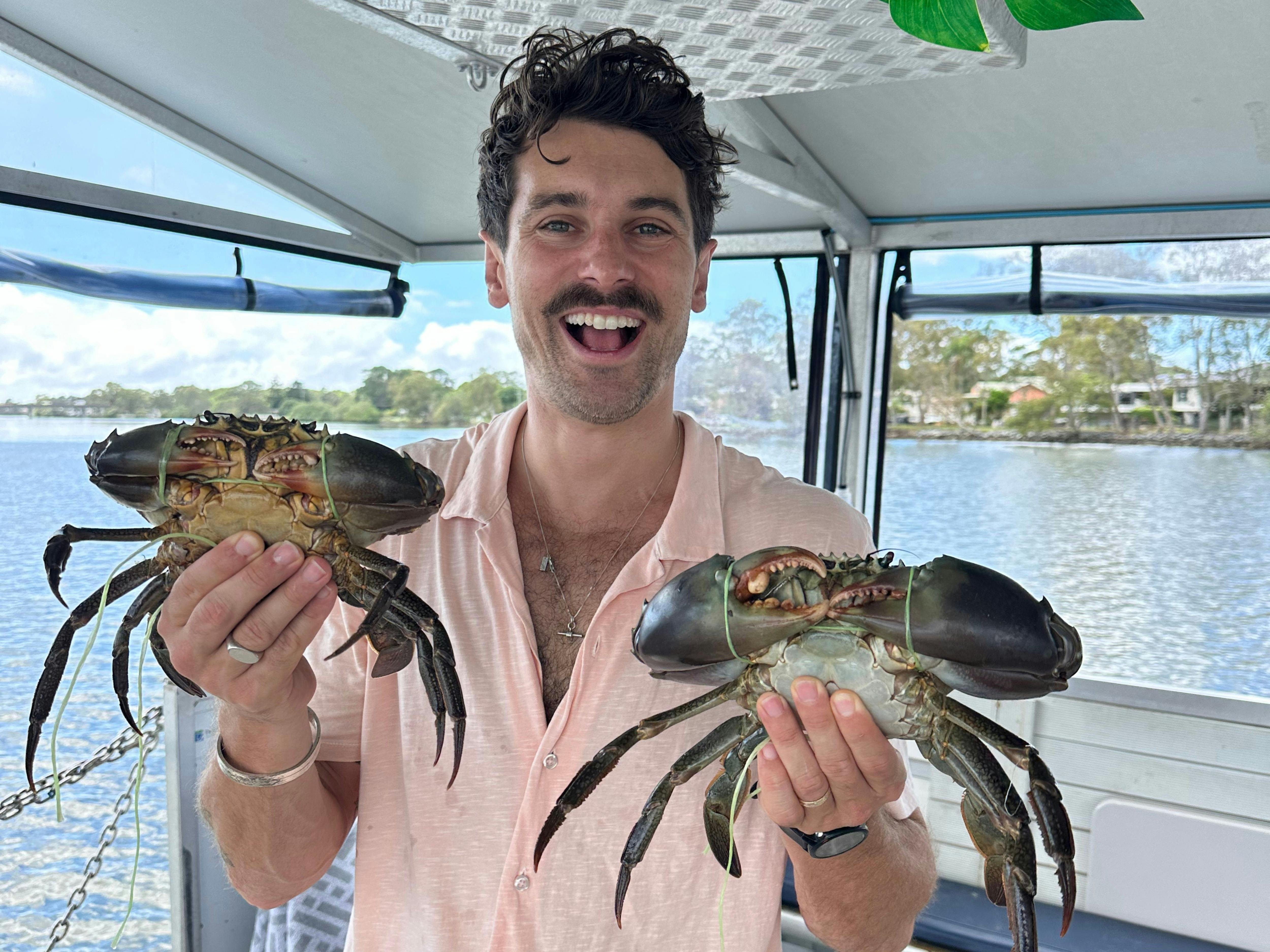 Picture of guests smiling holding caught mudcrabs.