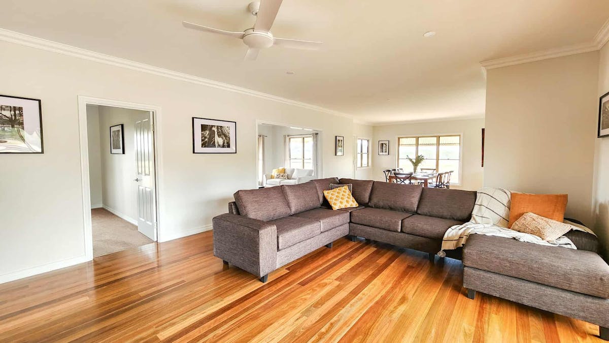 Spacious open living room with wood combustion heater and access to verandah