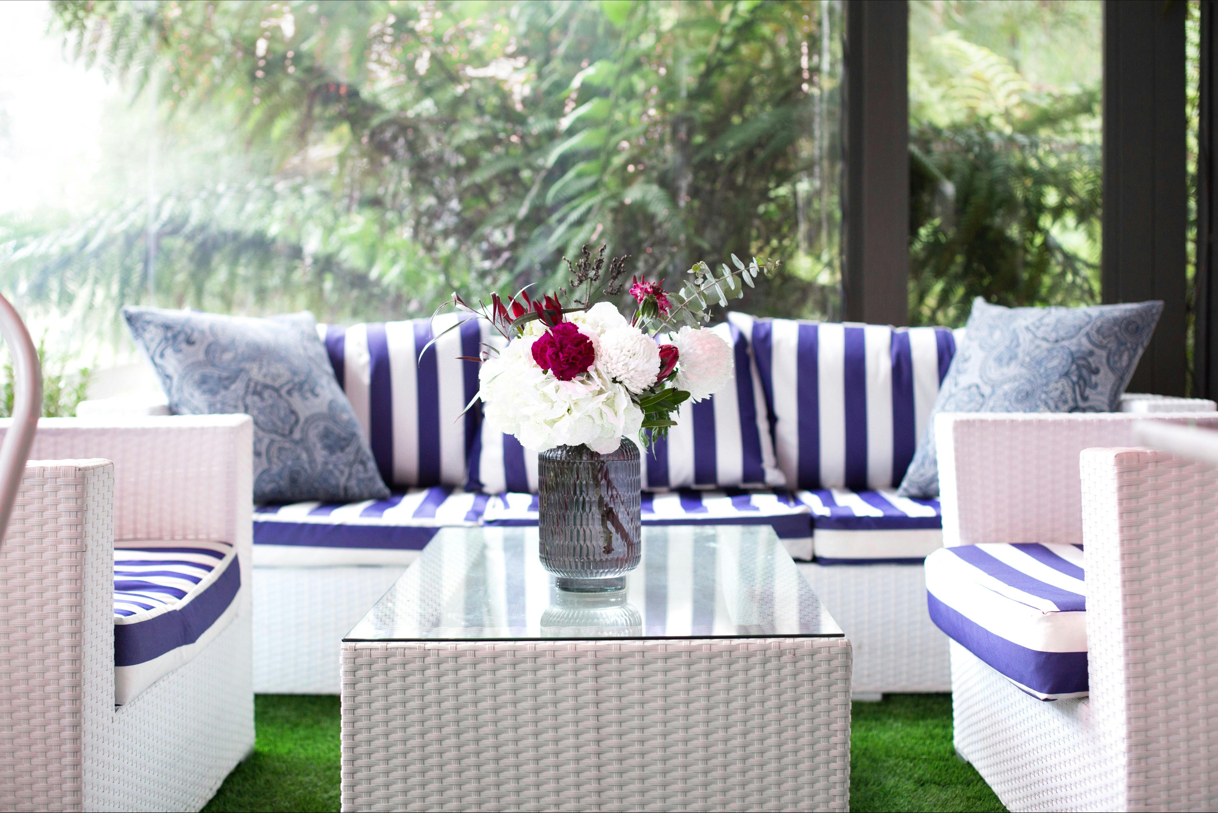 Fresh blue and white furniture by a window overlooking the rainforest garden