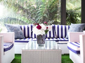Fresh blue and white furniture by a window overlooking the rainforest garden