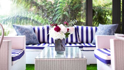 Fresh blue and white furniture by a window overlooking the rainforest garden