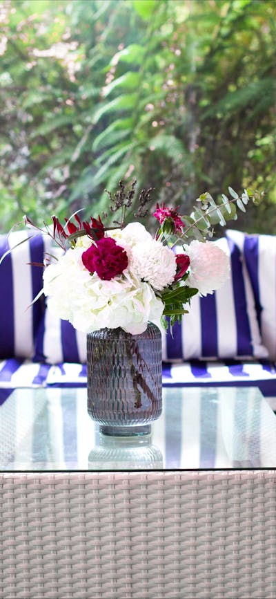 Fresh blue and white furniture by a window overlooking the rainforest garden