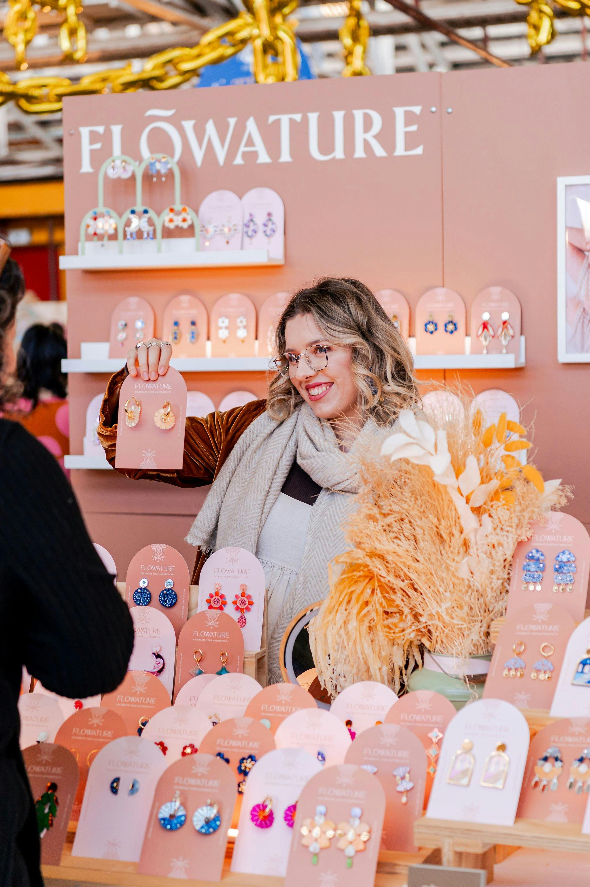 A beautiful lady holding up her gorgeous earrings to her customer