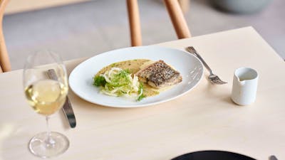 A fish dish and a glass of wine