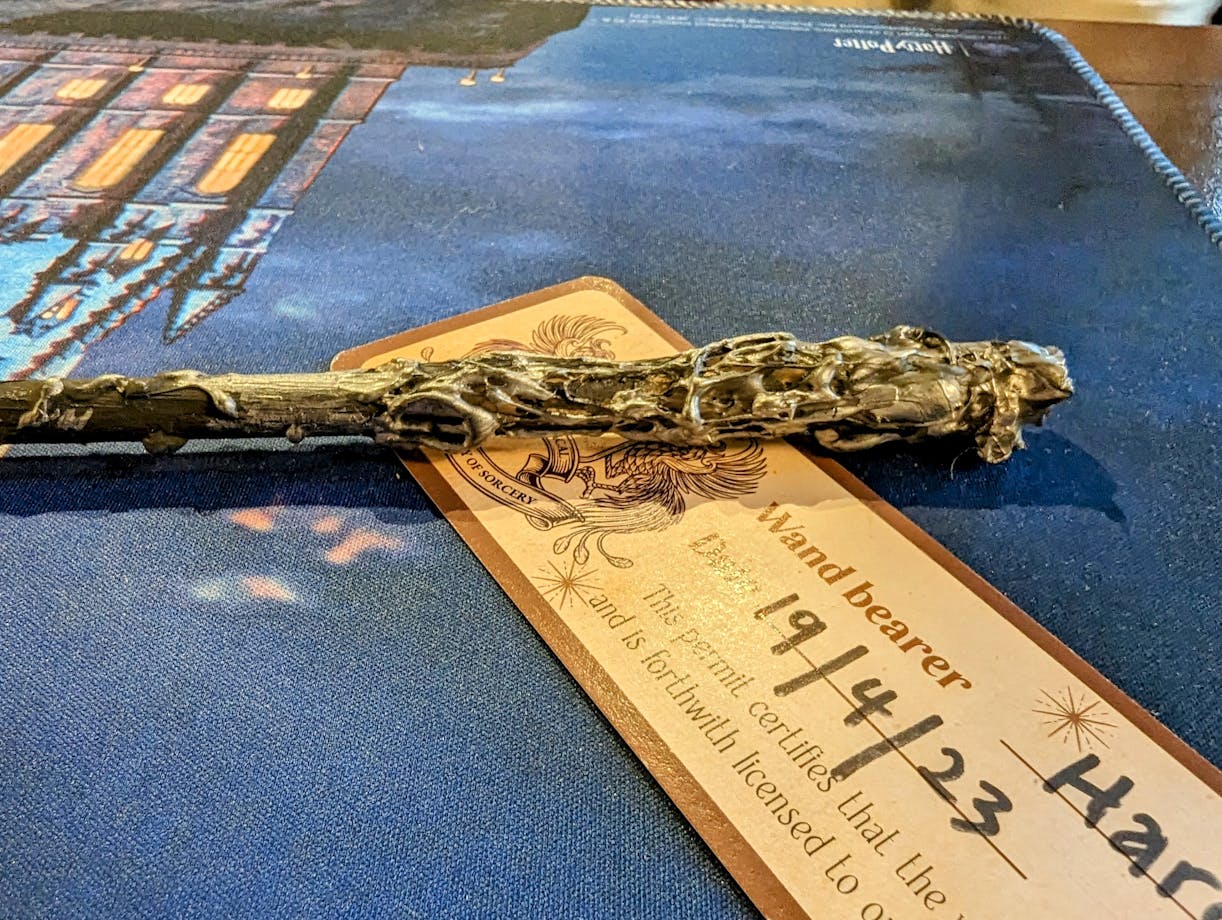 Photo of a handmade wand on a table with a completed wand license.