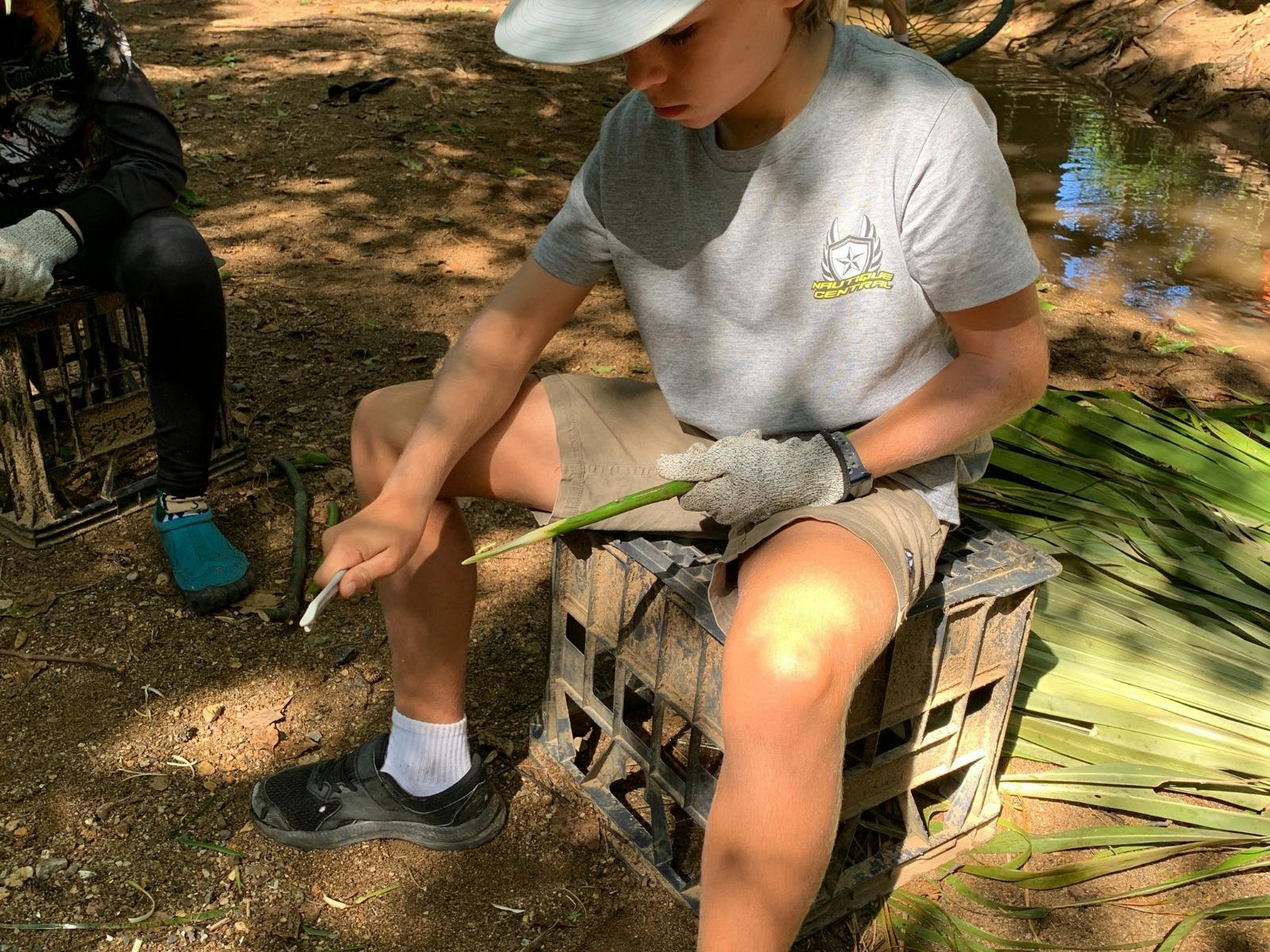 Child using tools for bushcraft at Birdwings Forest School Kids Holiday Nature Adventures Gold Coast