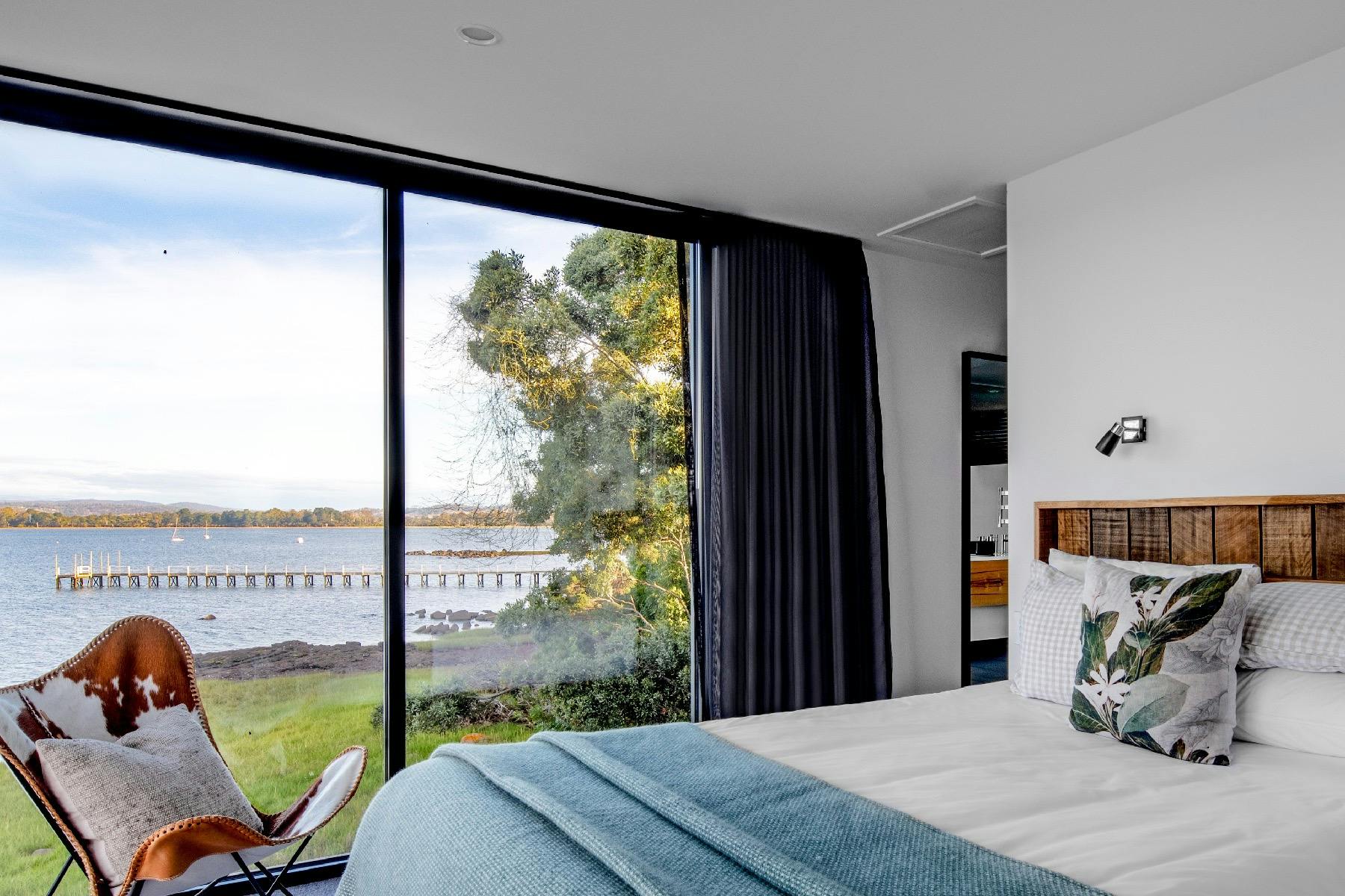 The main bedroom has 90 degree views of the river including a lovely vista of the old jetty.