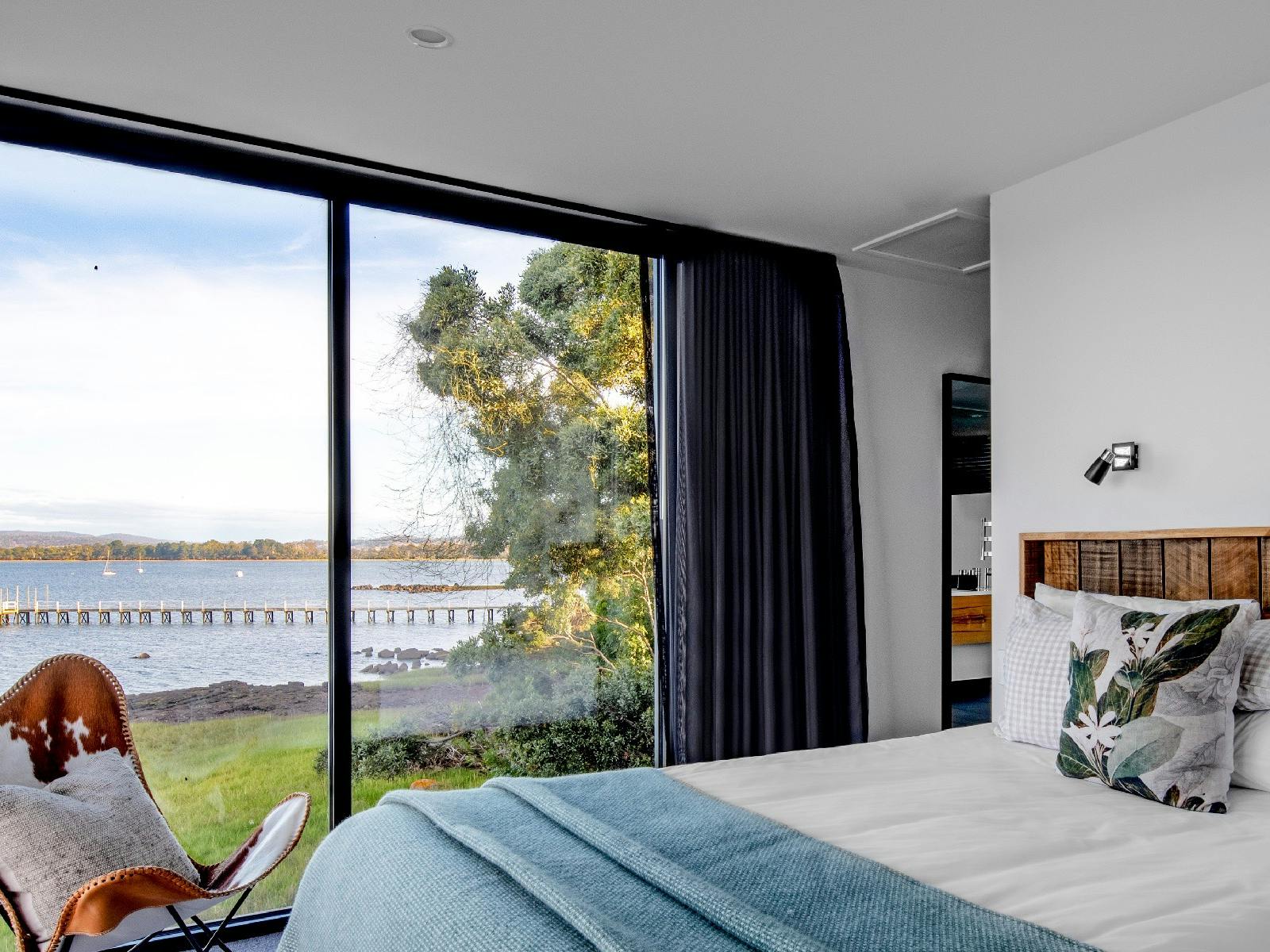 The main bedroom has 90 degree views of the river including a lovely vista of the old jetty.