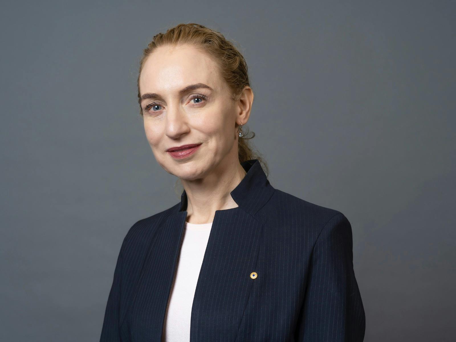 Headshot of a woman wearing a white shirt and blazer