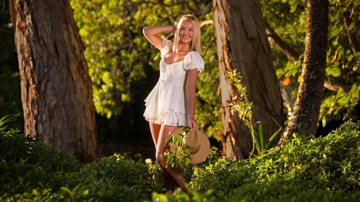 Young woman enjoying a holiday photography experience in tropics in Queensland, wearing a ligh