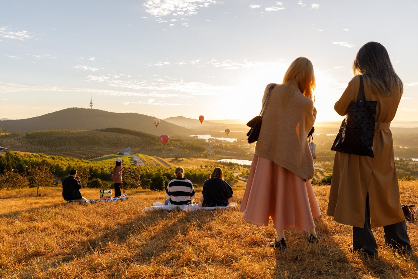 People up at lookout location to watch the balloons float over the Canberra skyline