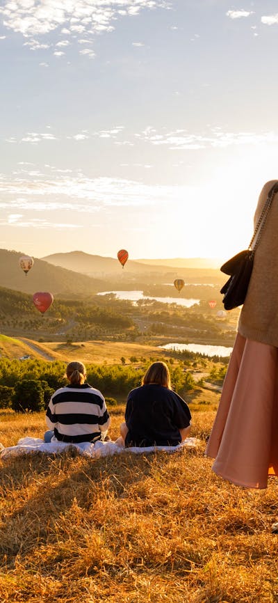 People up at lookout location to watch the balloons float over the Canberra skyline