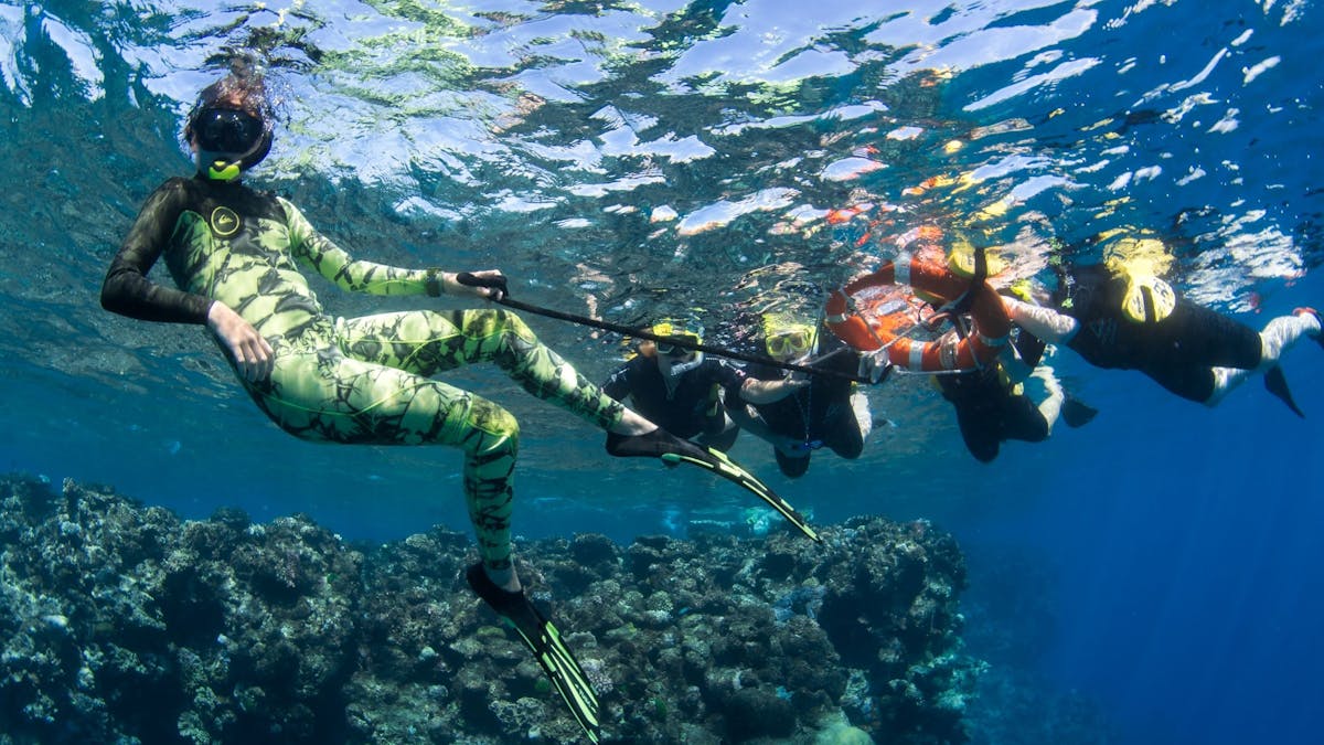 A crew memeber of Passions of Paradise assists passengers in the water using a life ring