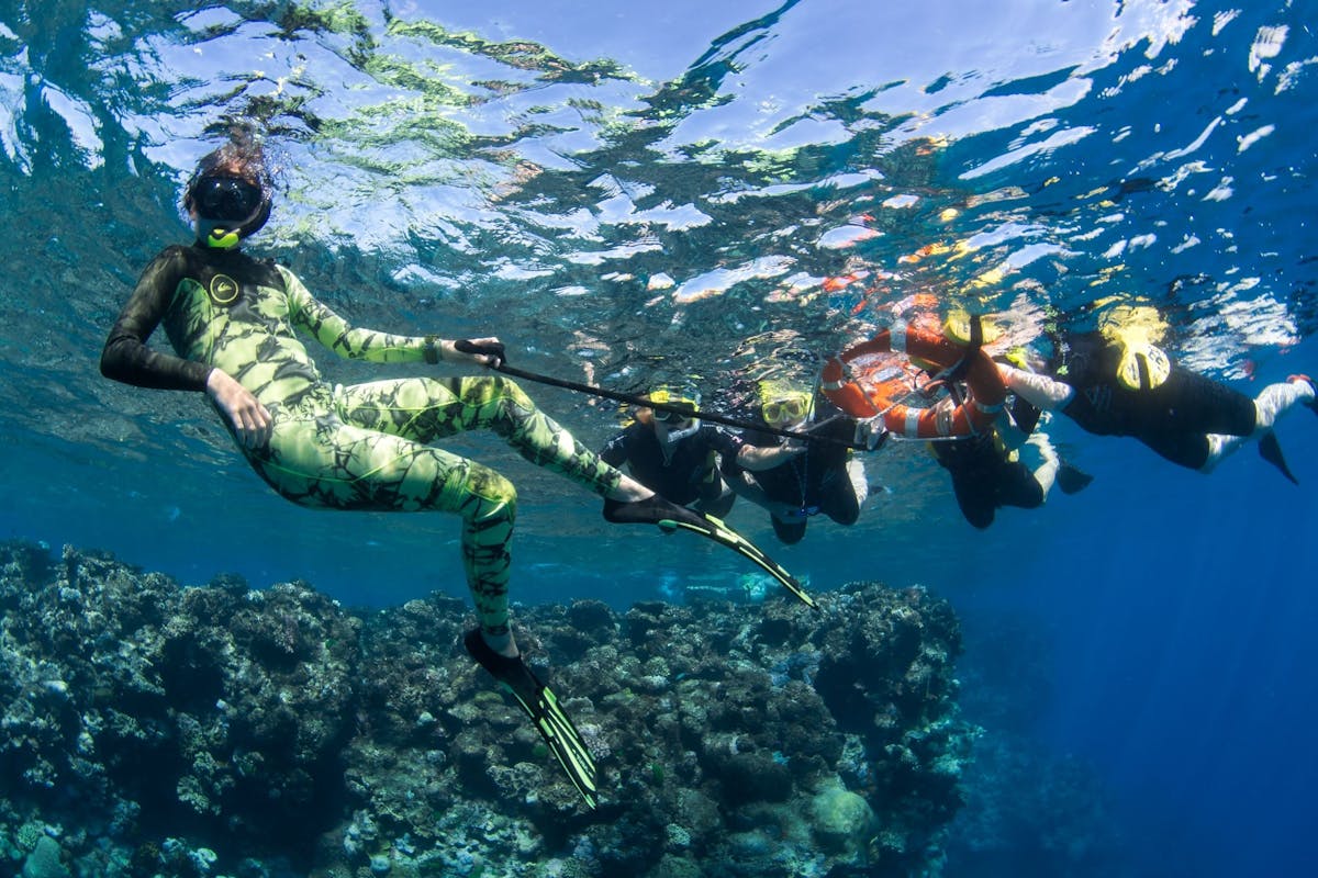 A crew memeber of Passions of Paradise assists passengers in the water using a life ring