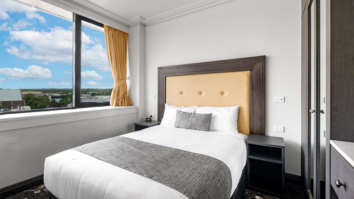 Corporate Queen Bed with a view to white clouds outside