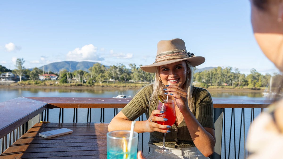 Two young women enjoying a cocktail at a restaurant by the Fitzroy River.