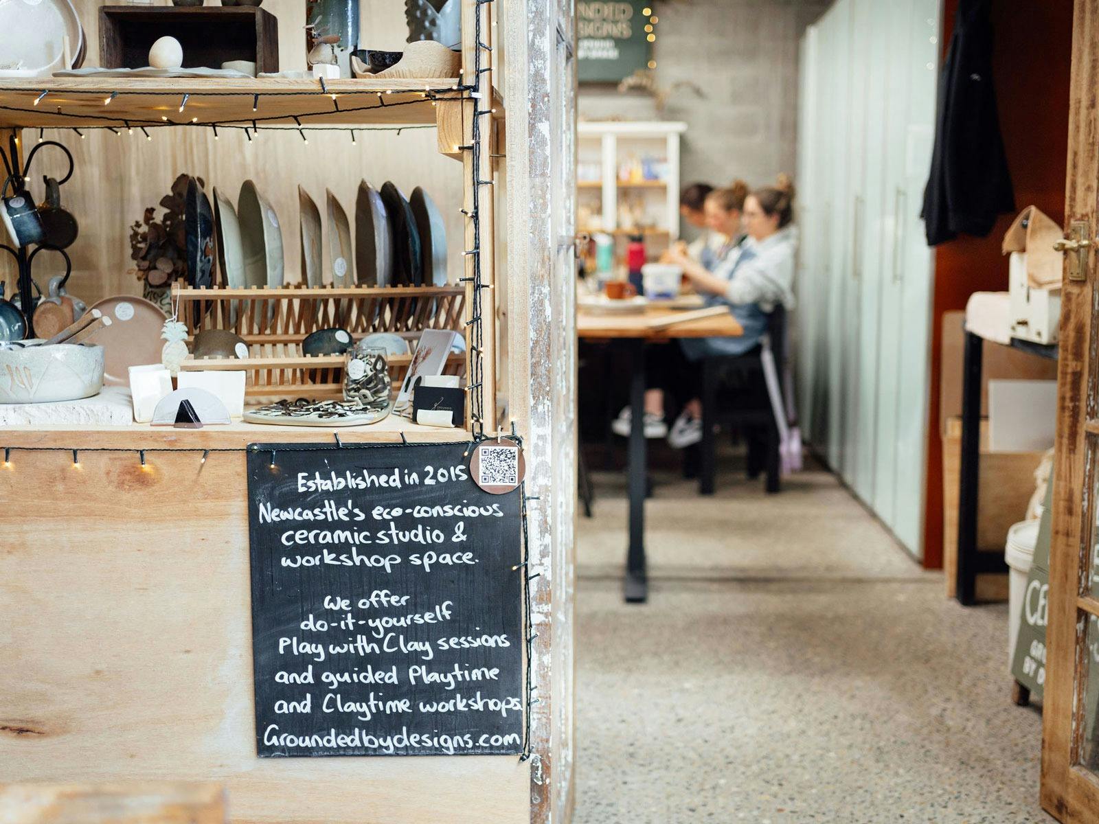 group of people blurred in the background of the studio with the foreground of homewares in focus