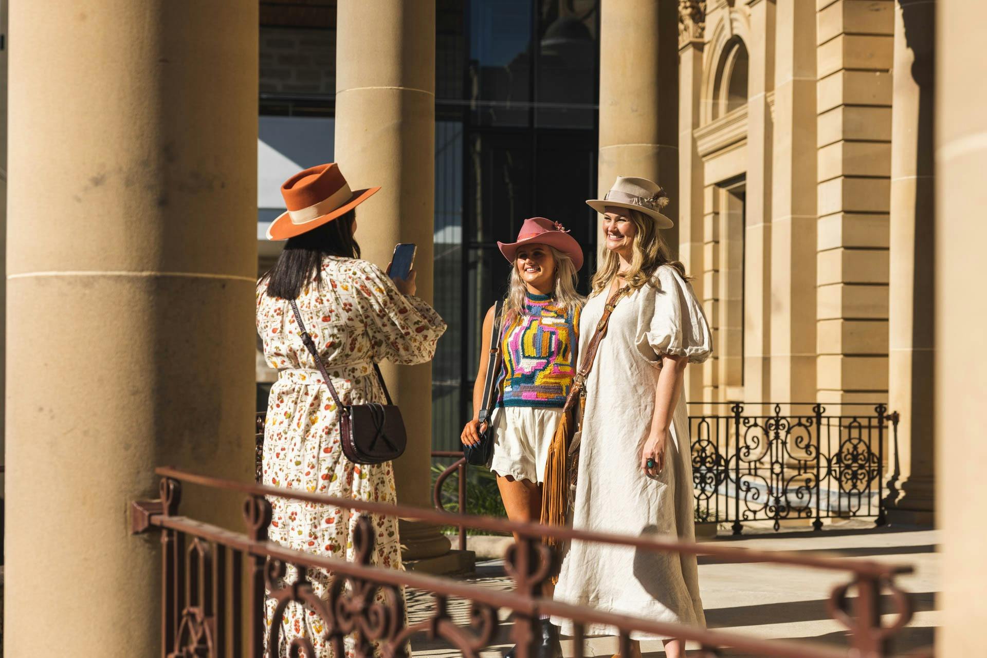 Three girls taking photos at Customs House