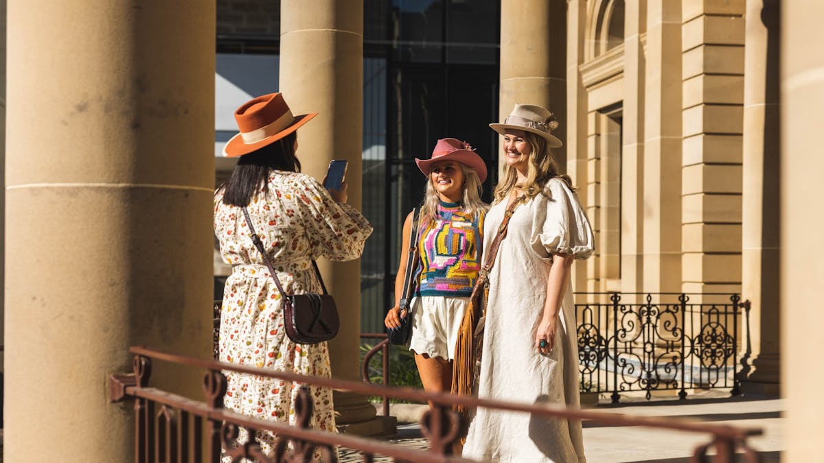 Three girls taking photos at Customs House