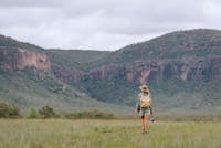 A woman hikes with a backpack, overlooking Mt Mulligan in the Mareeba Shire, North Queensland.