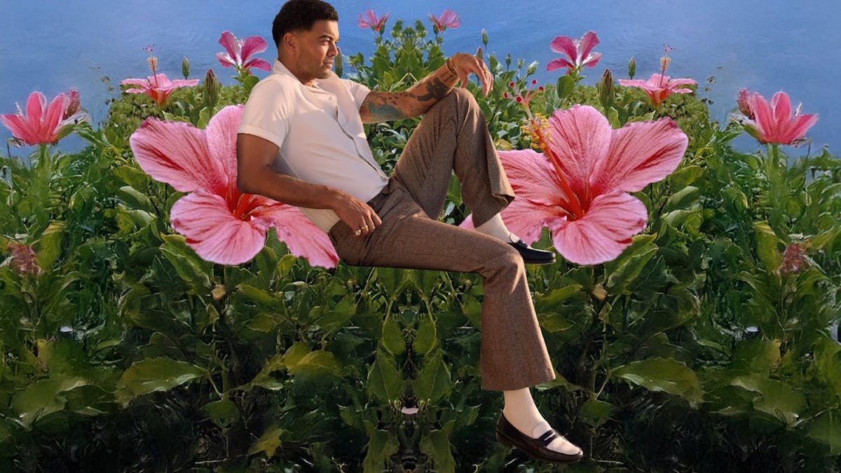 An olive skinned man sitting on pink hibiscus flowers