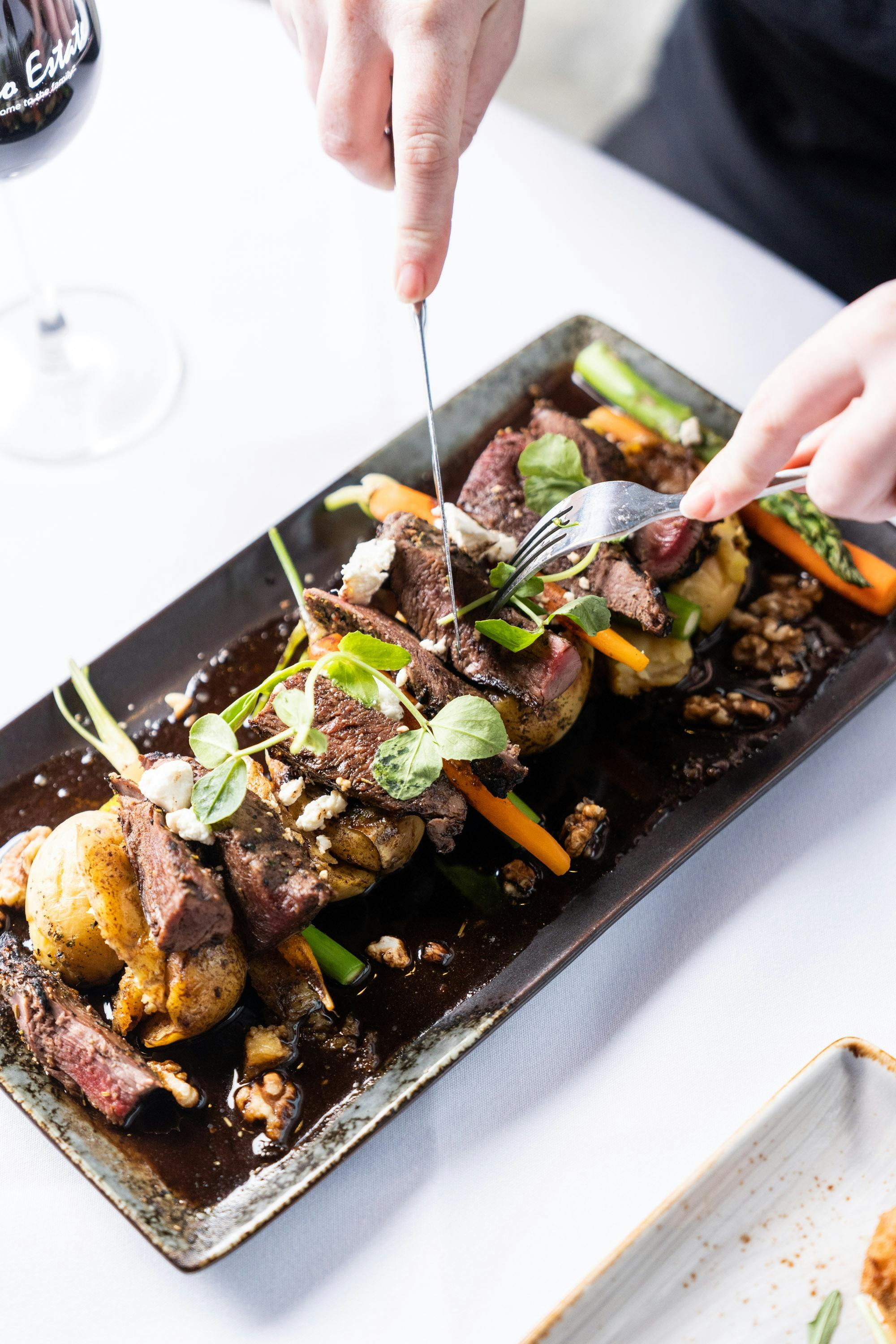 A plate of our tuscan lamb, with assorted veggies, chat potatoes, walnuts & goats cheese in  a jus