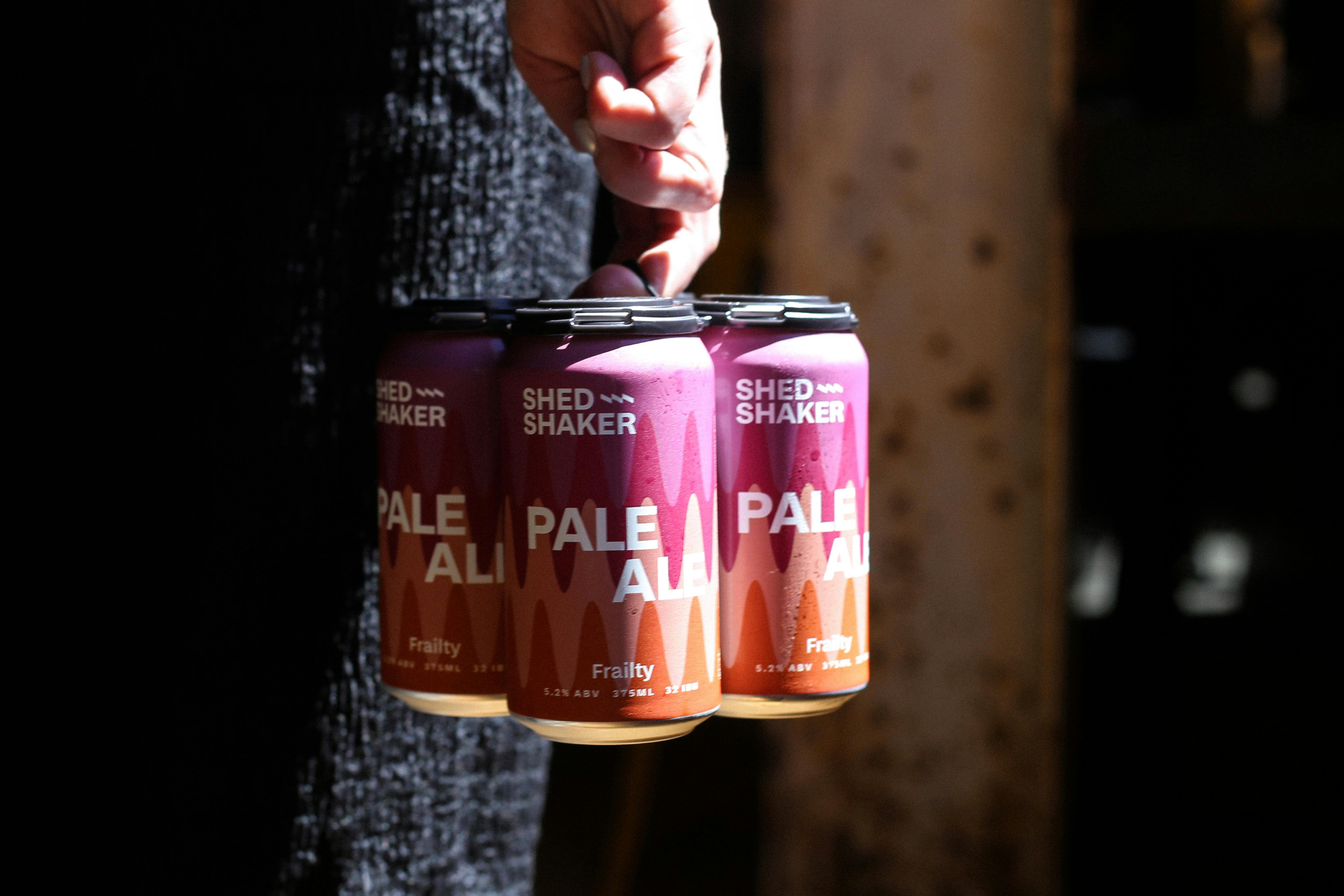 A four pack of beer being carried by a person